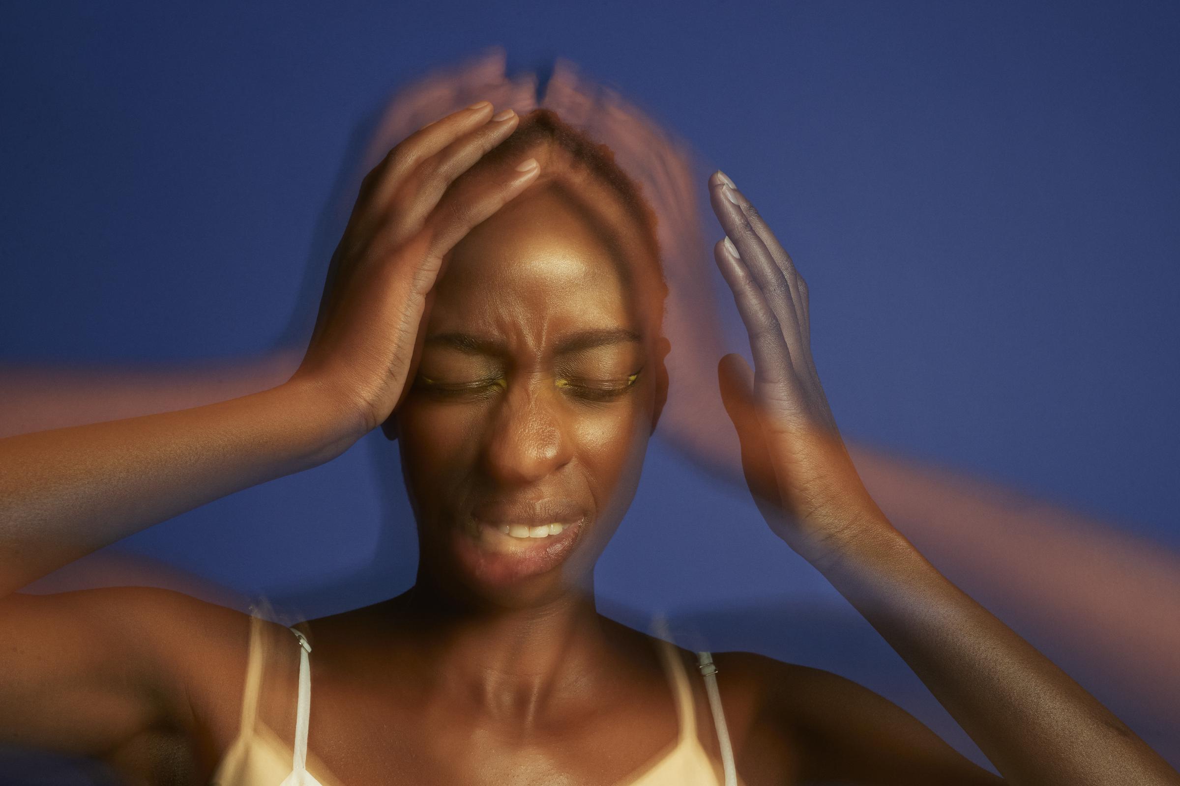 Mehrfach belichtetes Bild einer jungen Frau mit Kopfschmerzen, die ihren Kopf in den Händen hält und die Augen geschlossen hat | Quelle: Getty Images