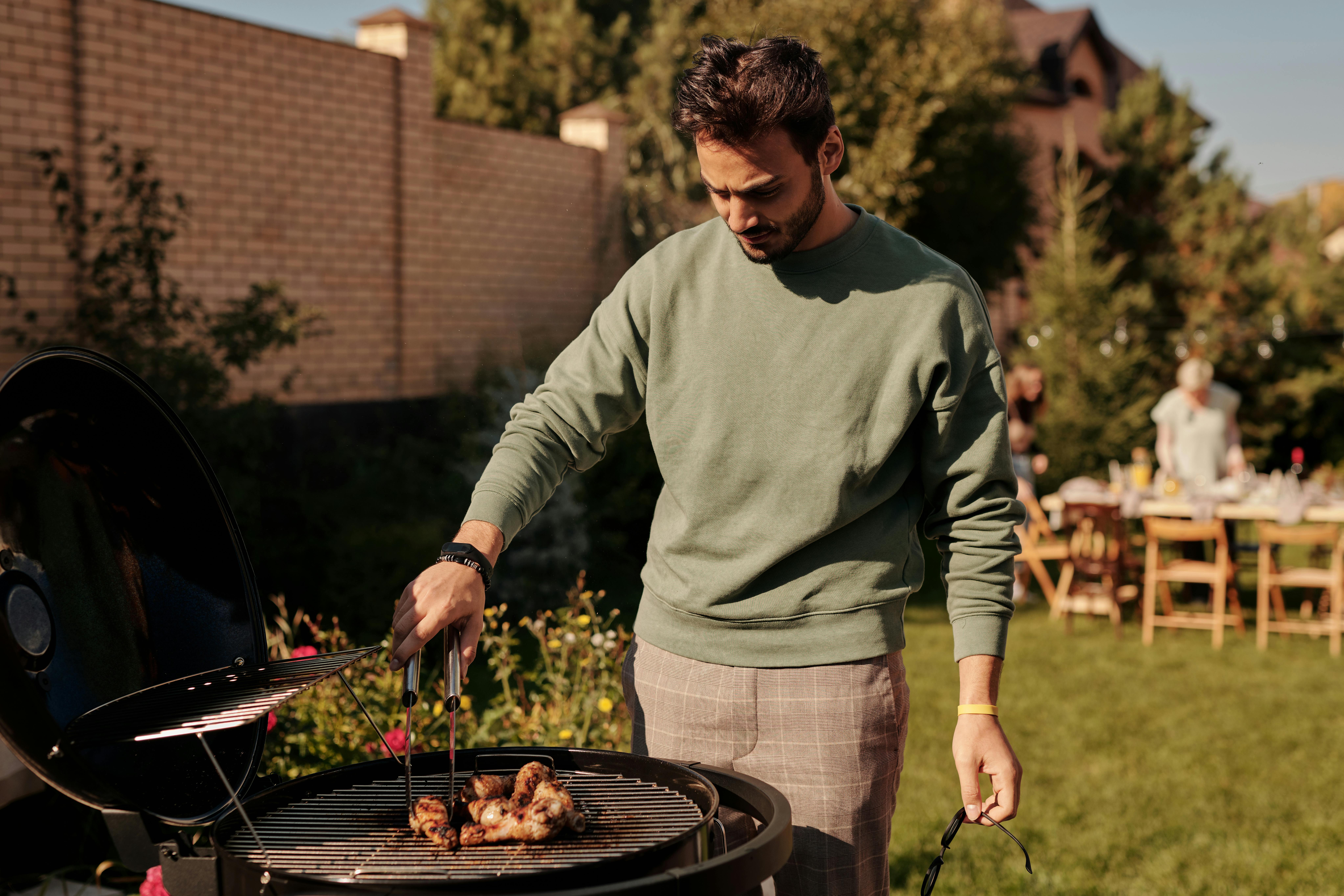 Mann kocht beim Grillen | Quelle: Pexels