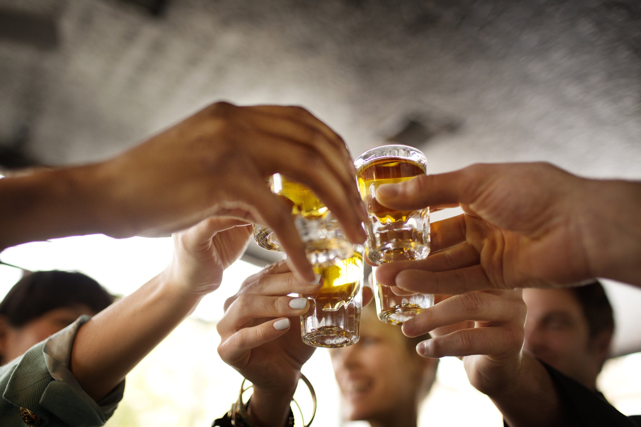 Freunde stoßen mit Shots von Tequila in einer Bar an. | Quelle: Getty Images