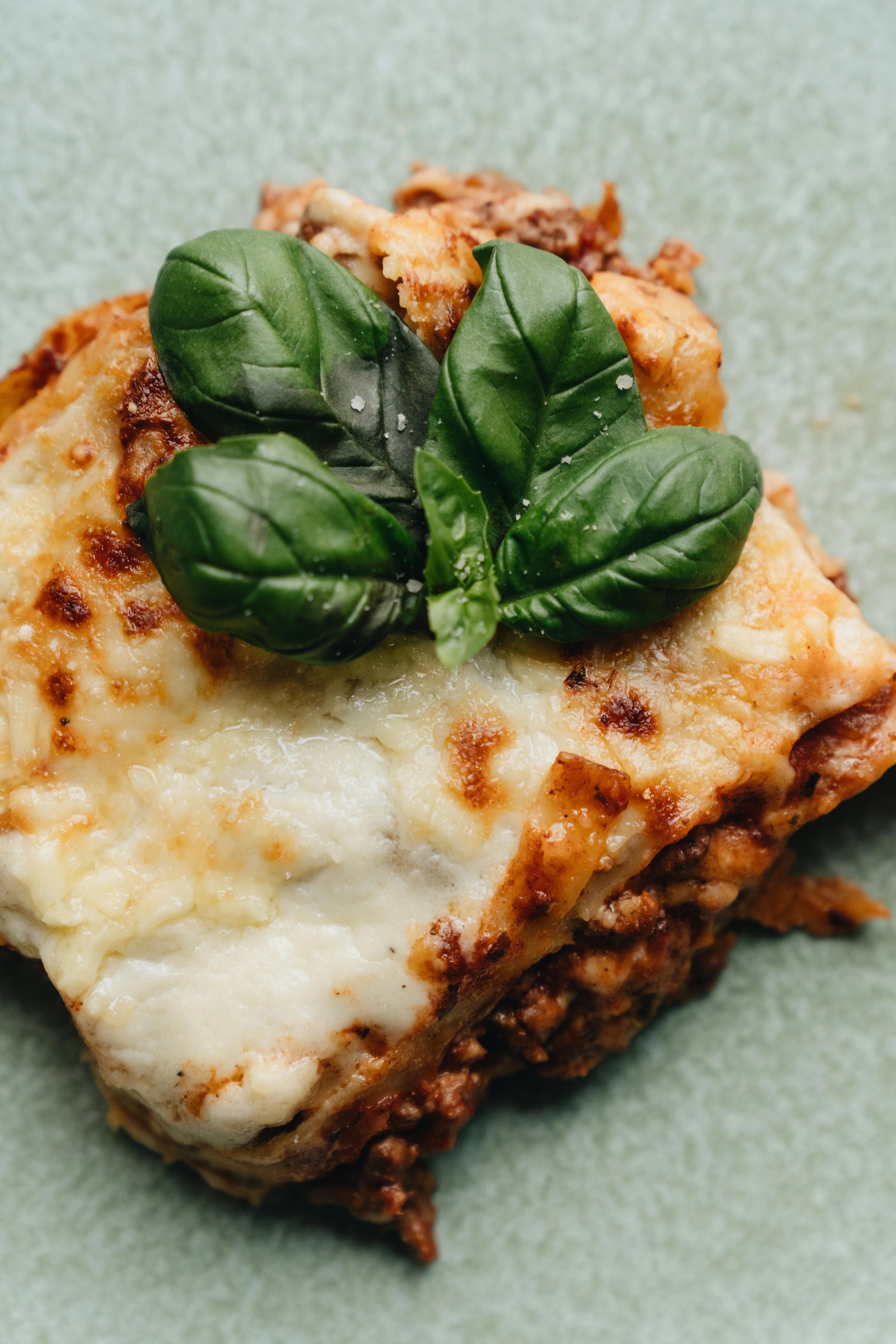 Ein Stück Lasagne garniert mit Basilikum | Quelle: Pexels