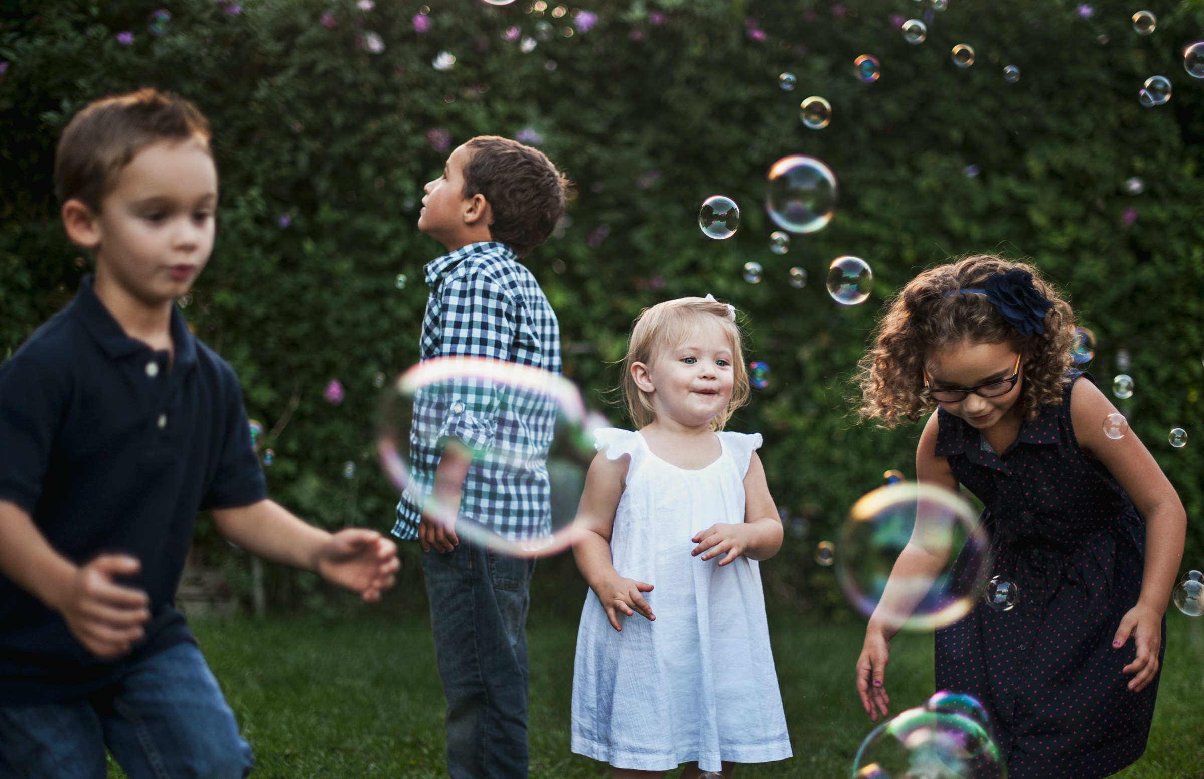Kinder spielen mit Seifenblasen im Freien | Quelle: Unsplash
