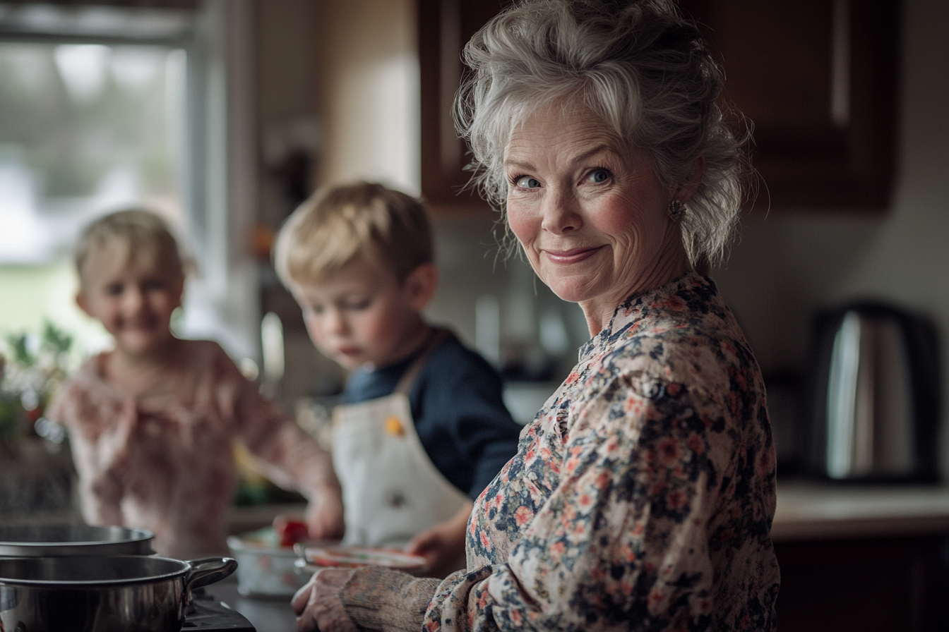 Eine Frau in den 60ern lächelt und kocht in einer Küche mit zwei Kindern im Hintergrund | Quelle: Midjourney