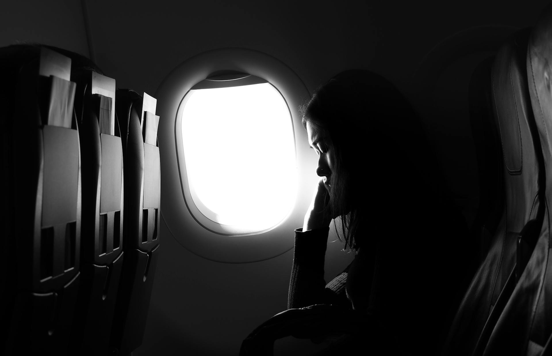 Eine junge Frau sitzt am Fenster in einem Flugzeug | Quelle: Pexels