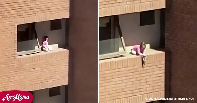 Ein schrecklicher Moment: Ein kleines Mädchen spielt mit der Puppe auf dem Gesims eines Balkons im vierten Stock