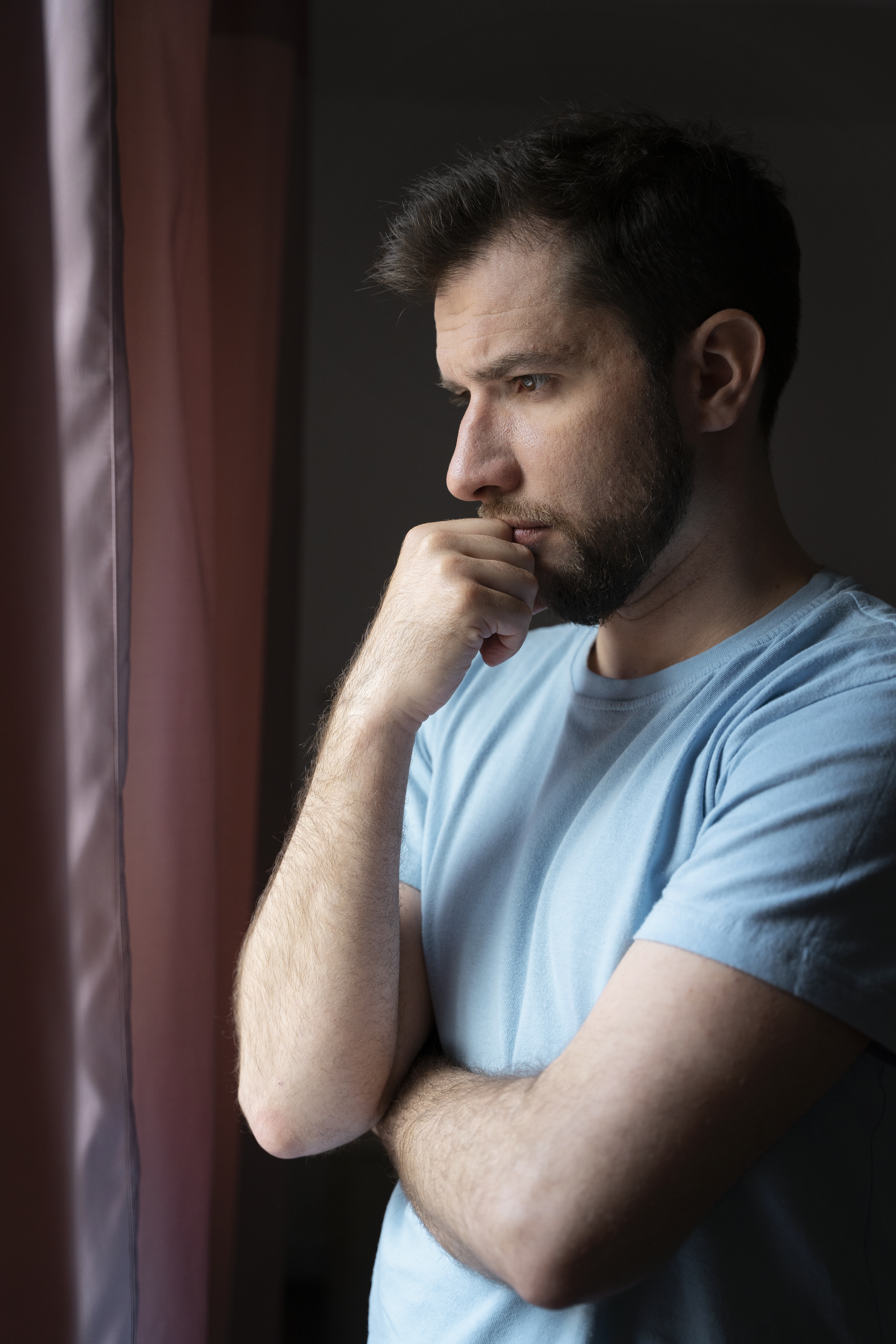 Mann denkt nach, während er vor einem Fenster steht | Quelle: Freepik.com