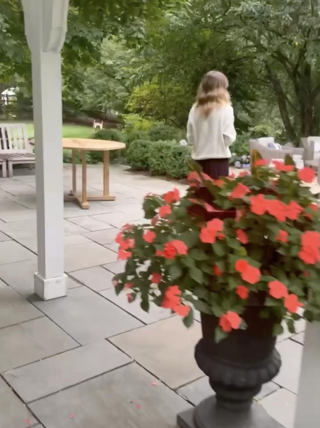 Silva zeigte einen Blick auf einen überdachten Sitzbereich im Freien mit Holztischen, Bänken und Blumen in Töpfen, von dem aus man auf die Gärten blicken kann. | Quelle: Instagram/alejandragere