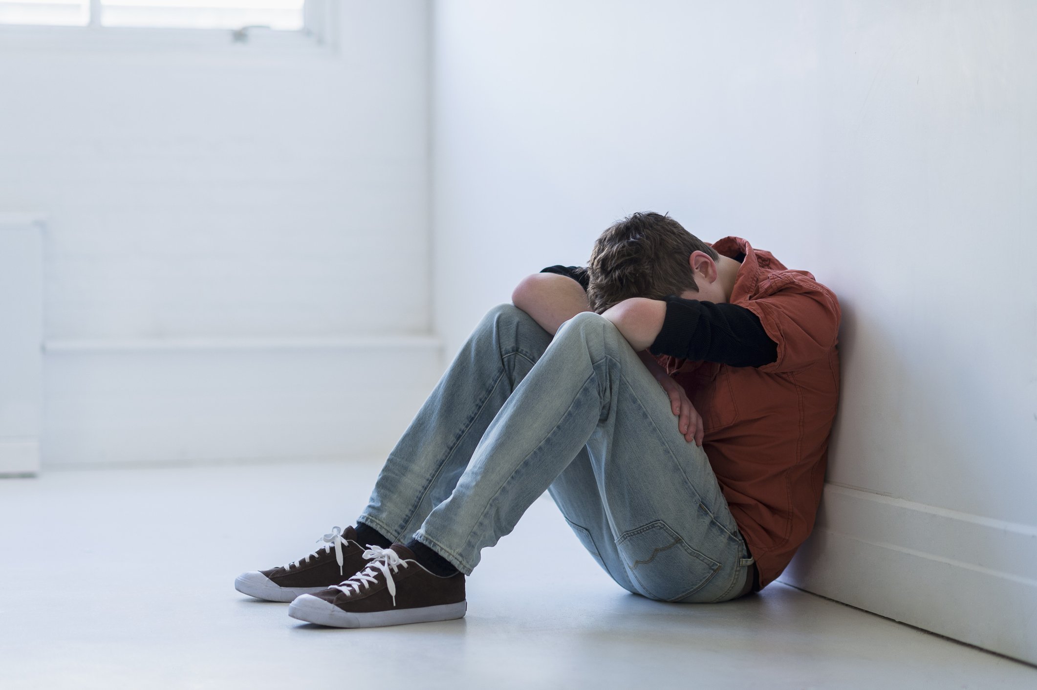 Depressiver Teenager sitzt im Flur. I Quelle: Getty Images