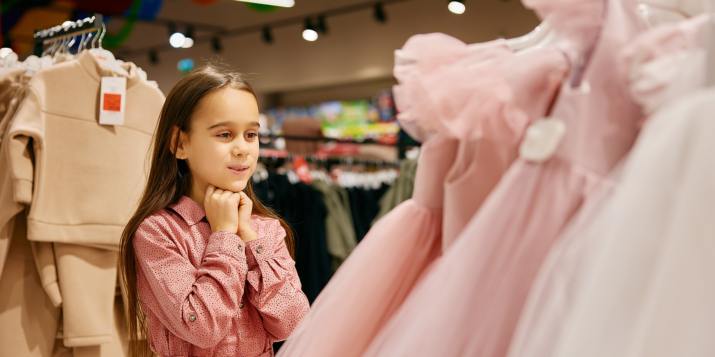 Ein kleines Mädchen sieht sich ein Kleid an | Quelle: Shutterstock