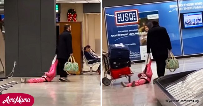 Ein müder Vater trägt seine Tochter an einem Flughafen auf eine kreative Weise