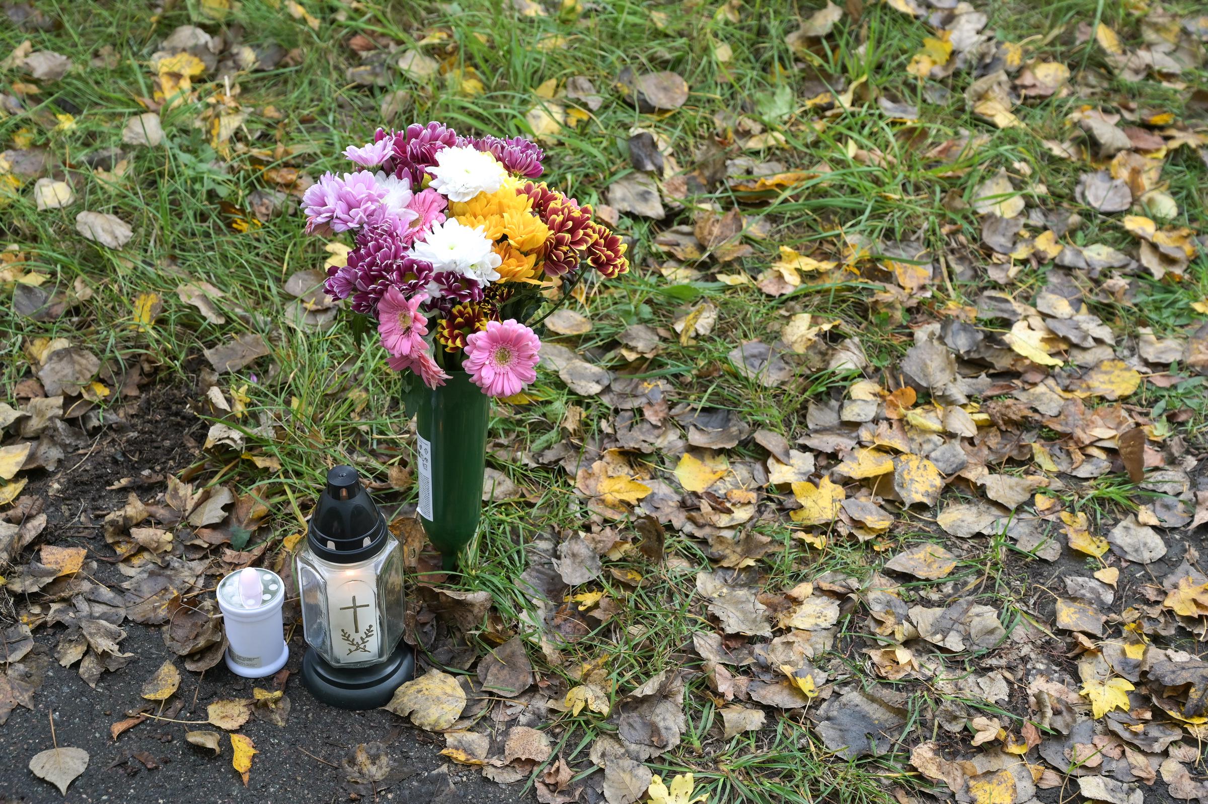 Menschen gedenken der Verstorbenen mit Blumen und Kerzen | Quelle: Getty Images