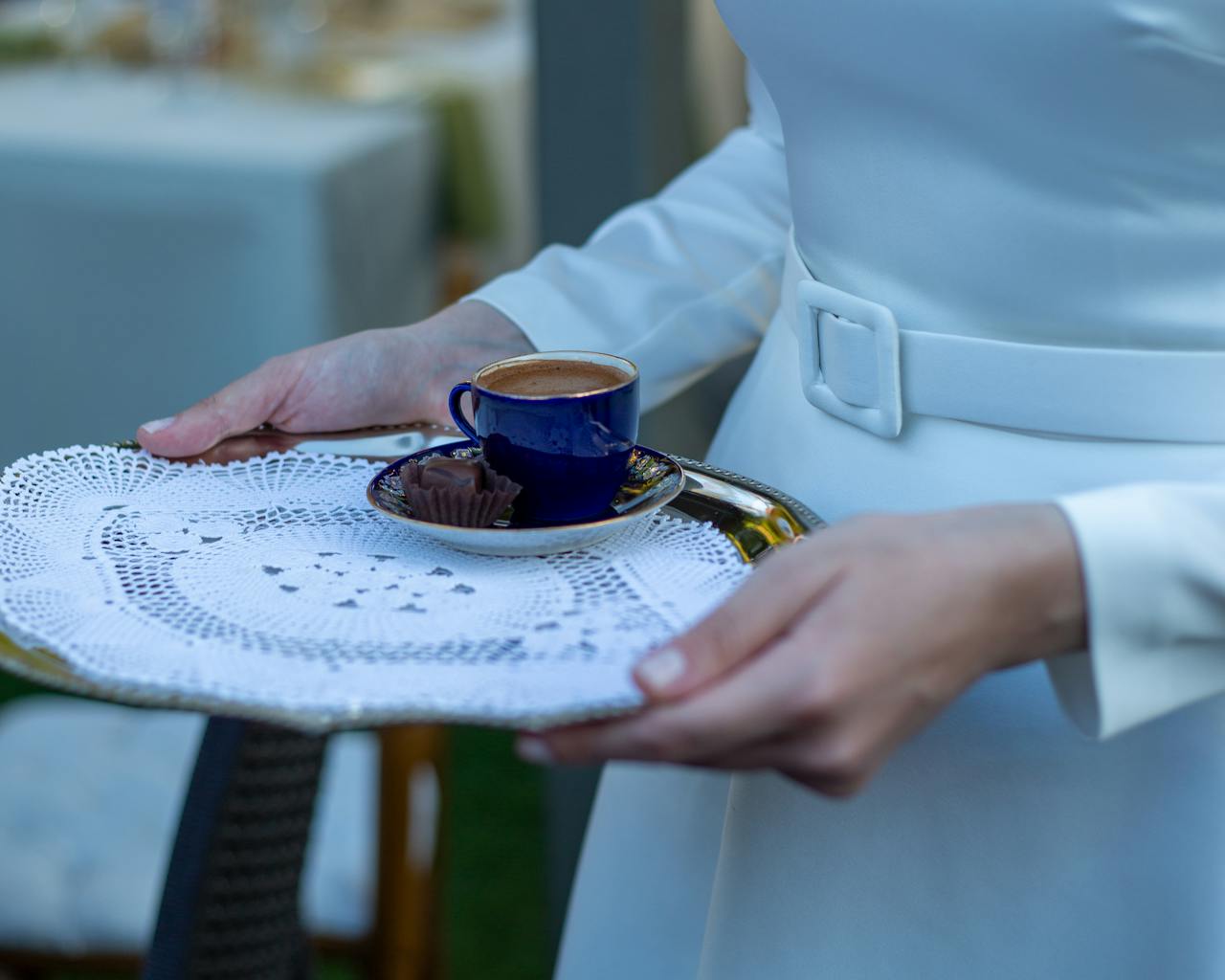 Eine Frau trägt ein Tablett mit einer Tasse Kaffee | Quelle: Pexels