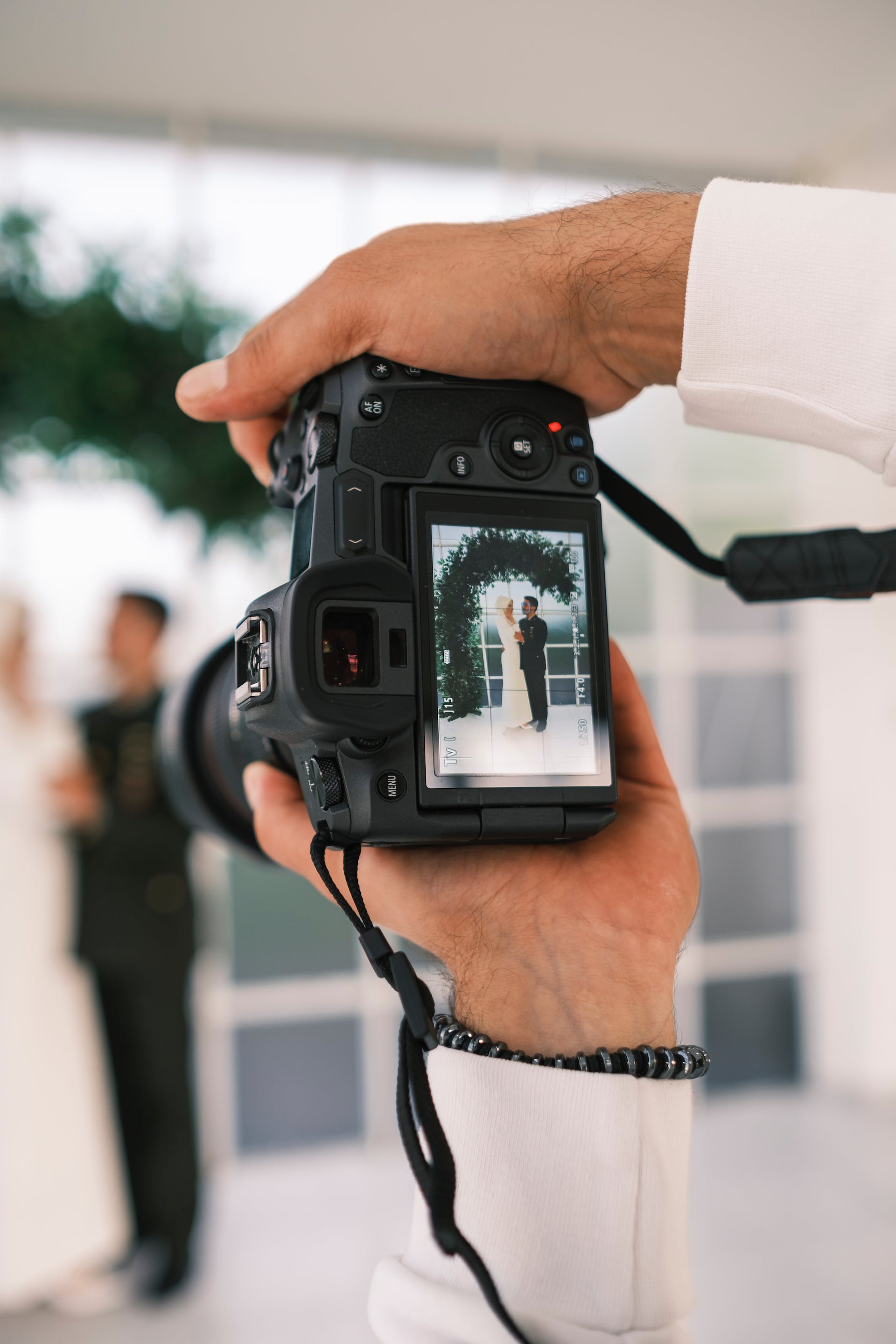 Ein Fotograf, der ein Paar bei seiner Hochzeit fotografiert | Quelle: Pexels