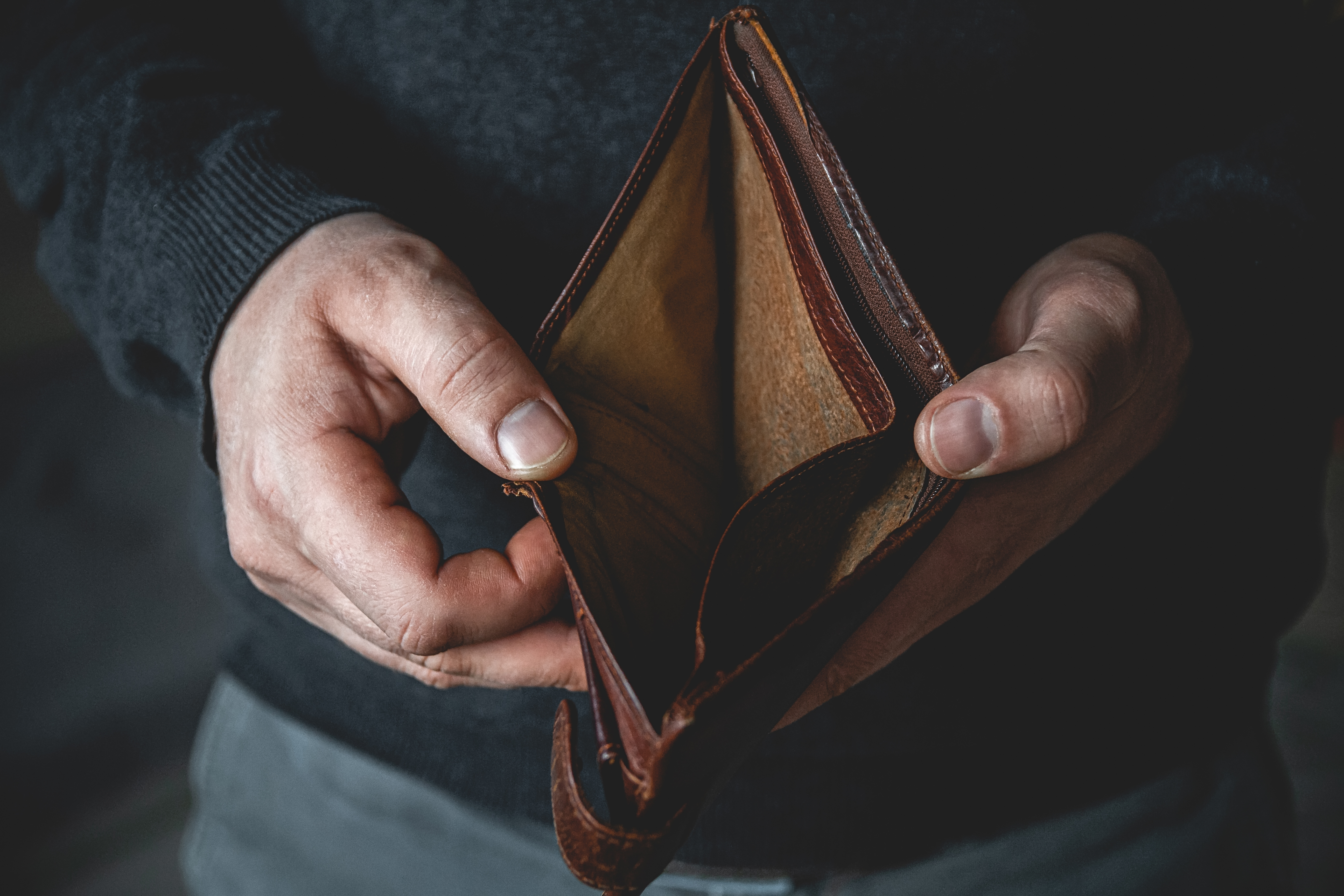 Ein Mann hält eine leere Brieftasche | Quelle: Shutterstock