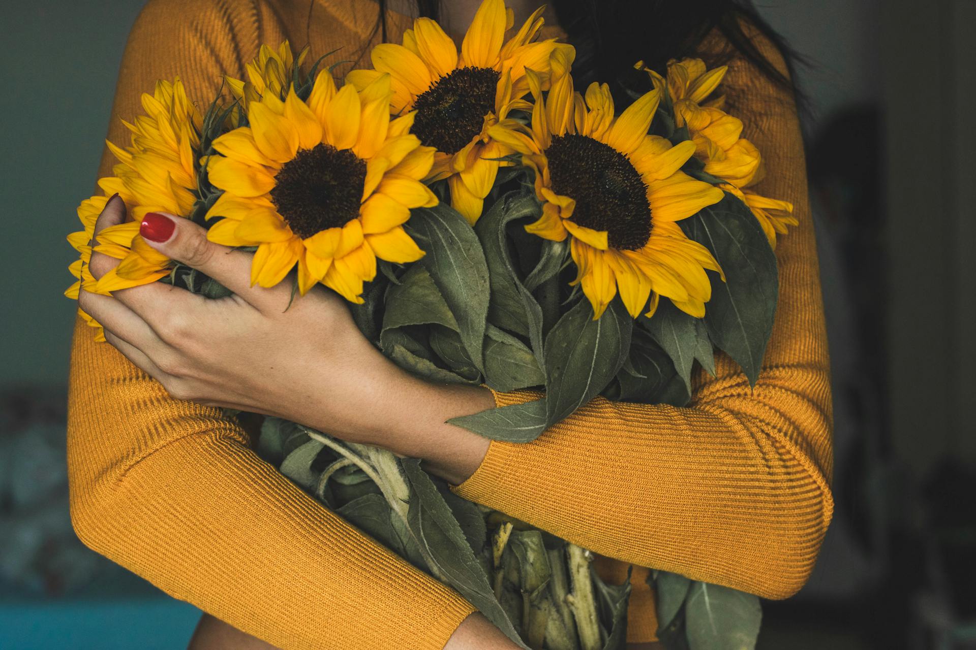 Eine Frau hält einen Strauß Sonnenblumen | Quelle: Pexels