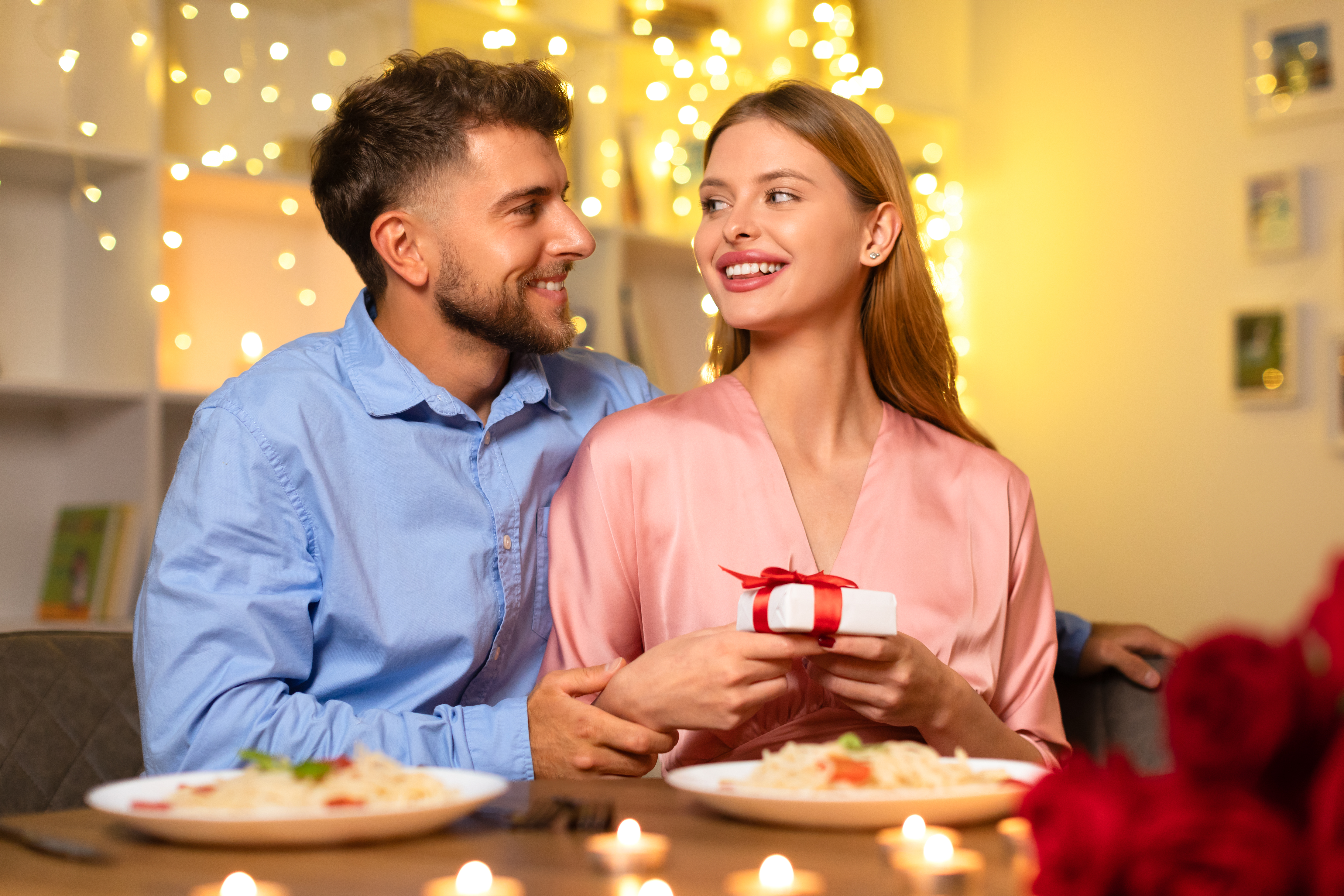 Ein glückliches Paar, das seinen Jahrestag bei einem Abendessen mit Kerzenlicht feiert | Quelle: Getty Images