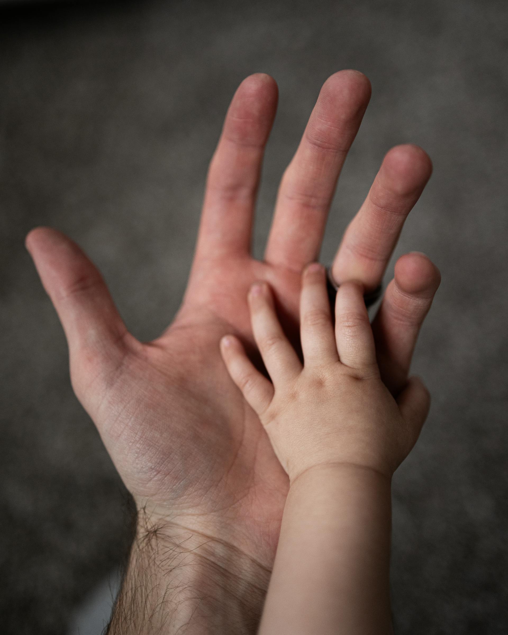 Ein Mann und die Hände eines Babys | Quelle: Pexels