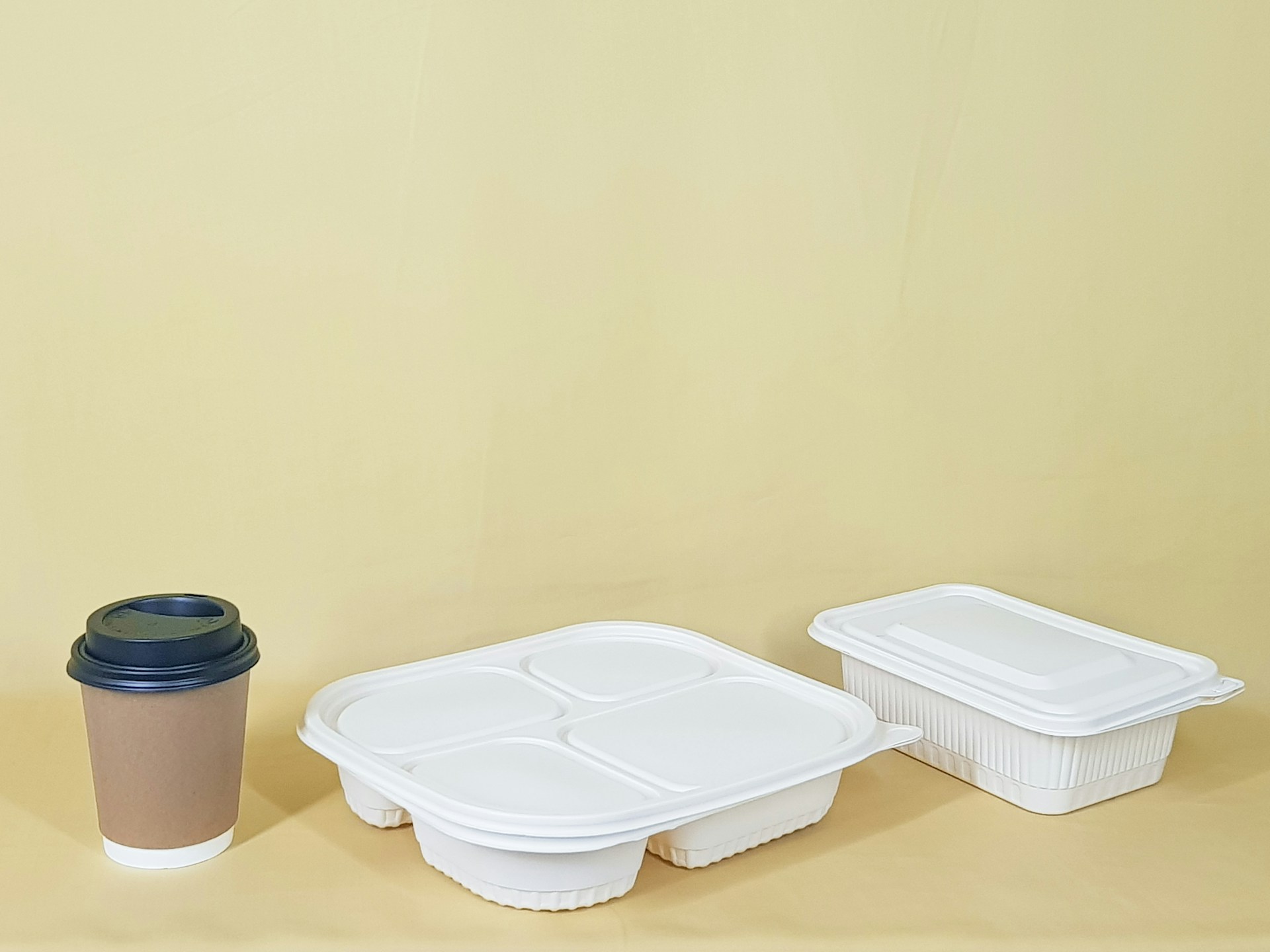 Ein Becher neben zwei Lebensmittelbehältern | Quelle: Unsplash