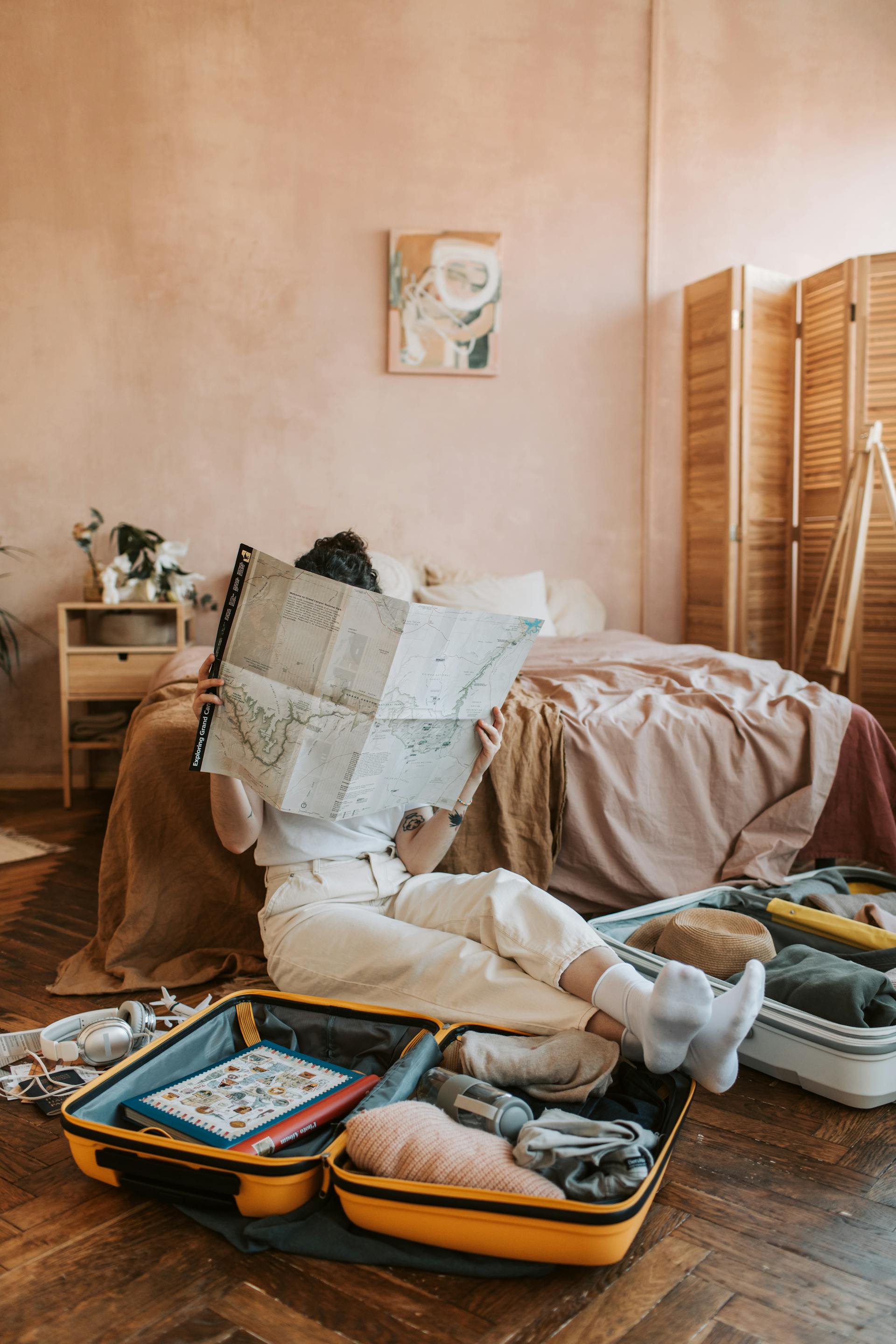 Eine Frau, die auf eine Karte schaut, während um sie herum Gepäckstücke sitzen | Quelle: Pexels