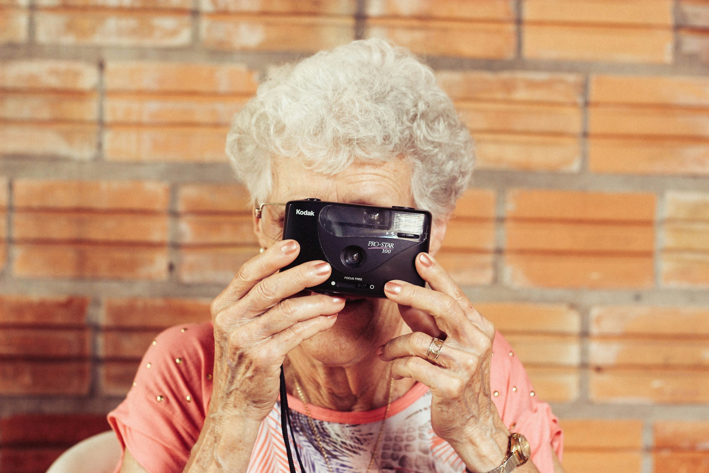 Eine ältere Frau hält eine Kamera | Quelle: Unsplash