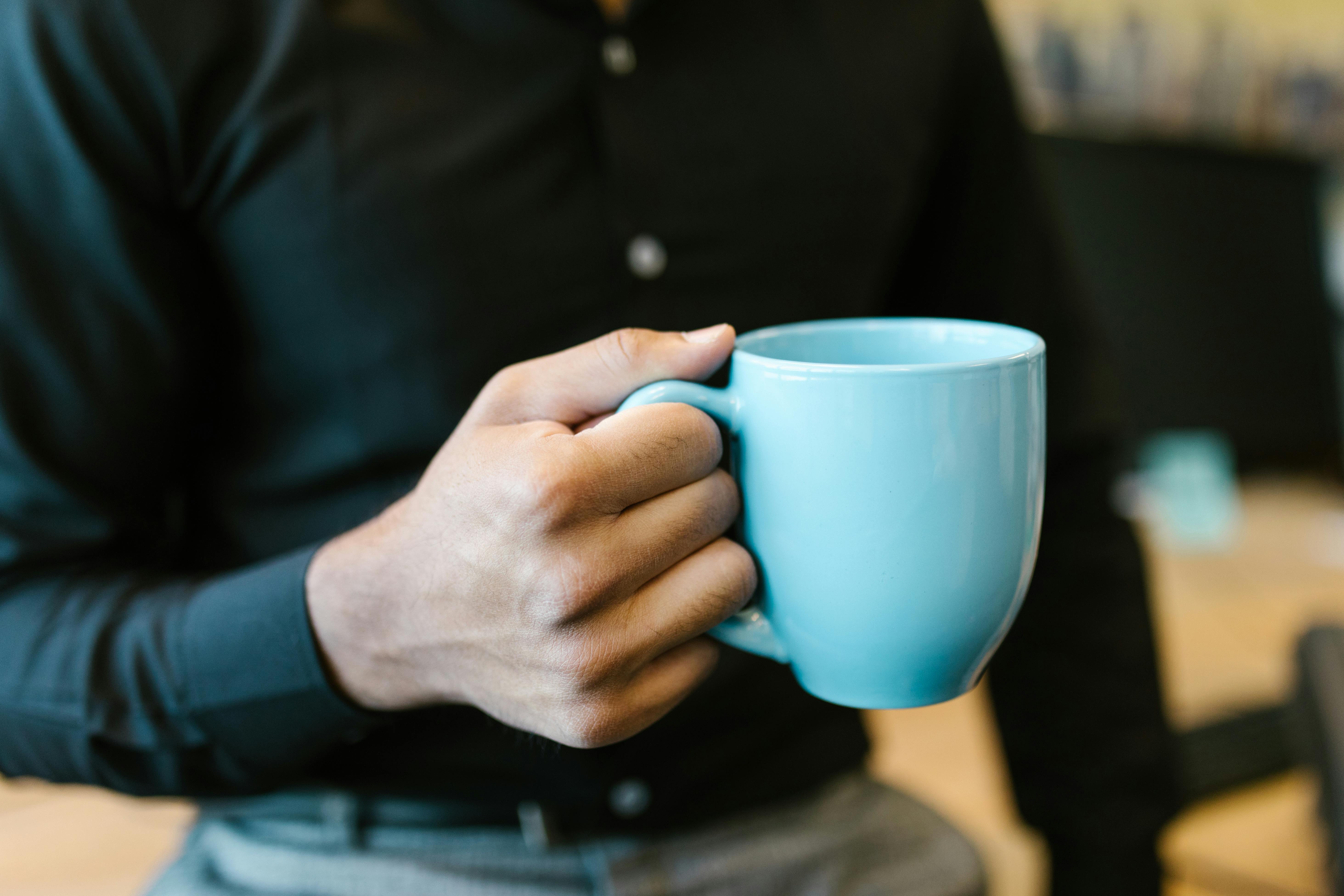 Eine Person hält einen Keramikbecher | Quelle: Pexels