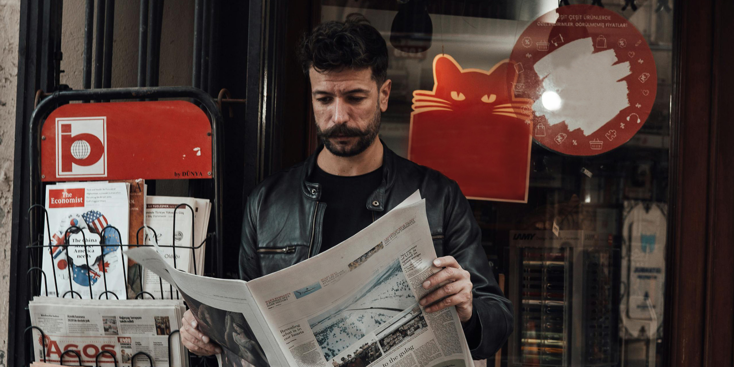 Ein Tourist liest eine Zeitung in einem Buchladen | Quelle: Pexels
