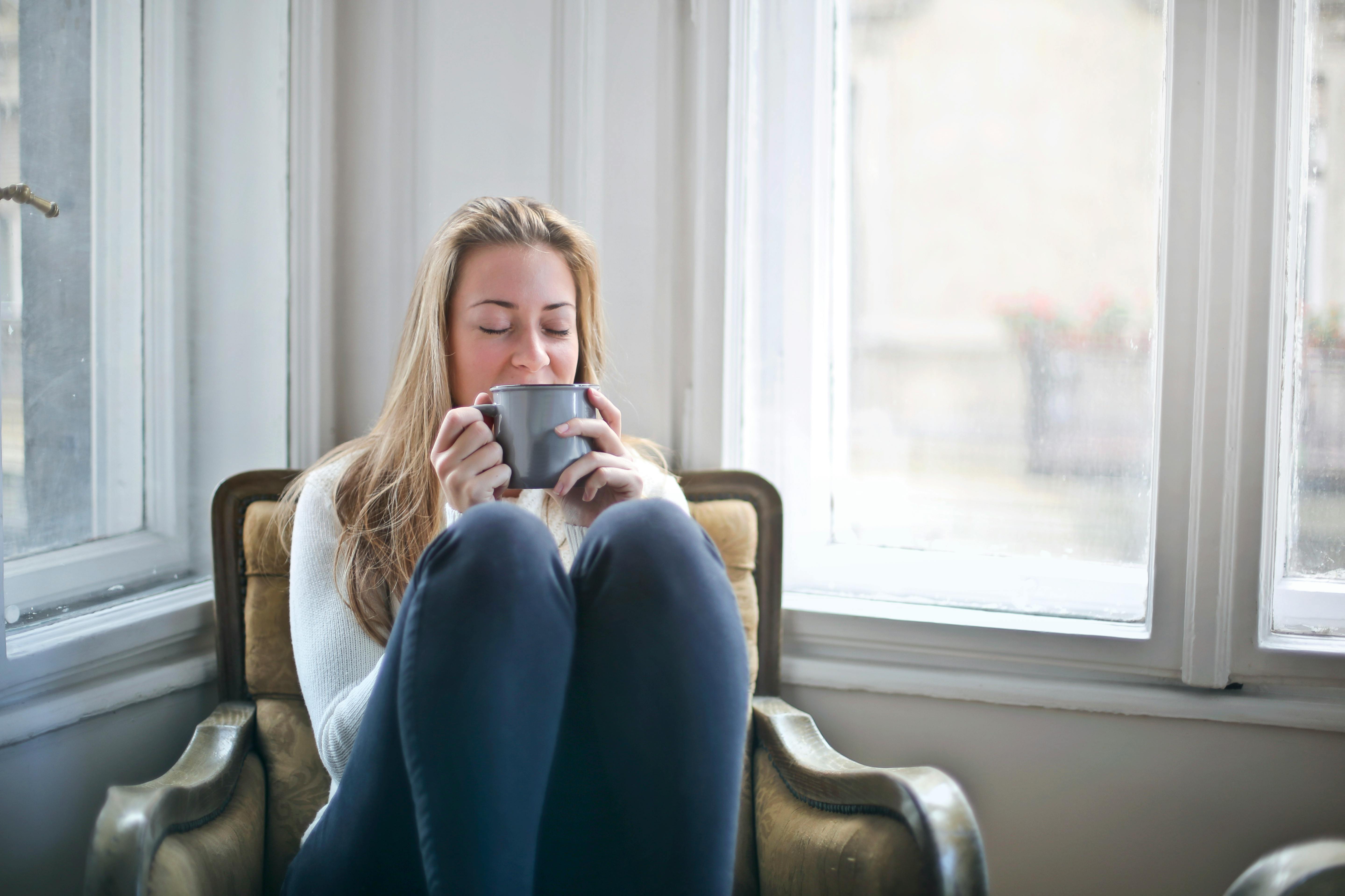 Frau hält einen grauen Keramikbecher | Quelle: Pexels