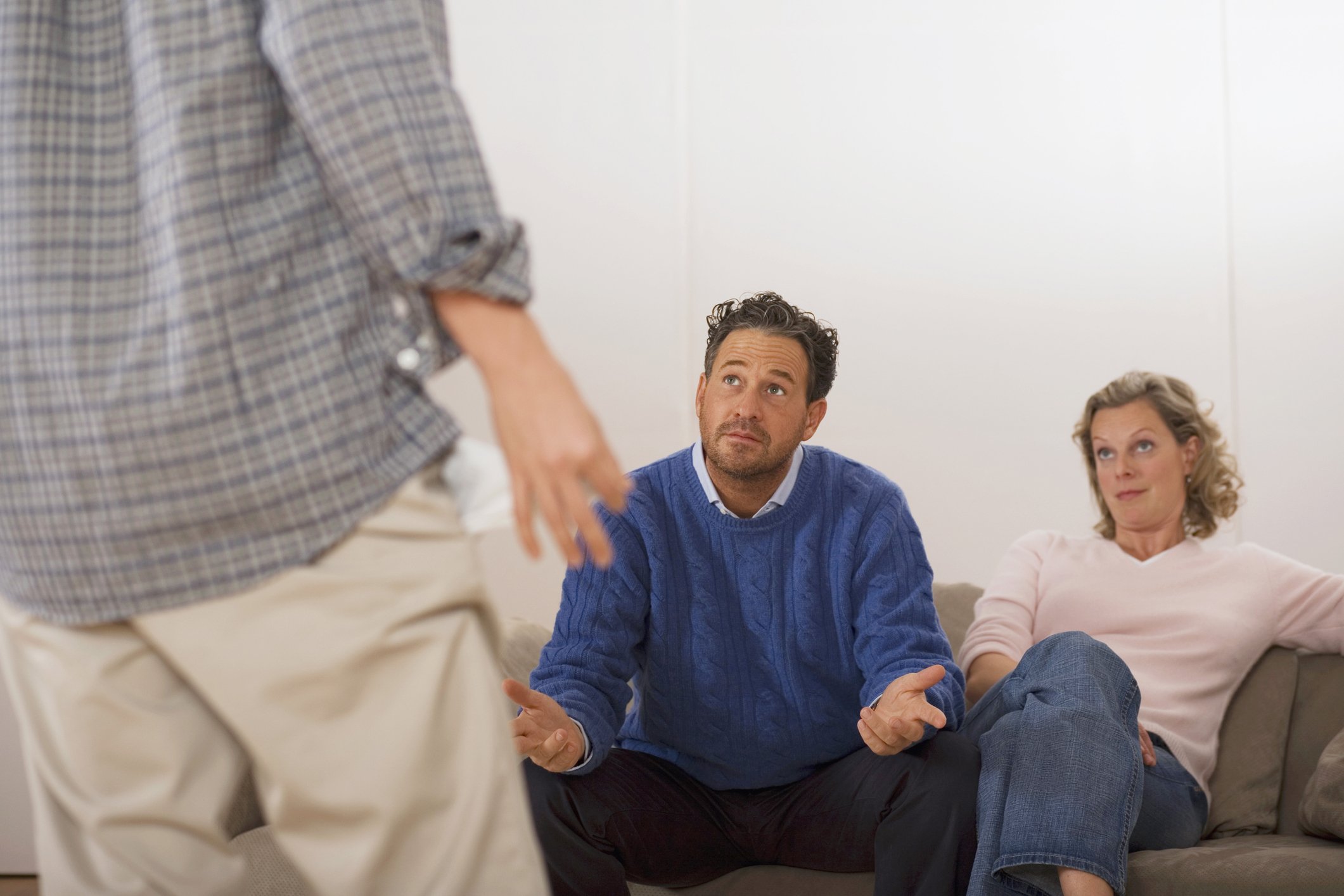 Eltern diskutieren mit Sohn, Rückansicht | Quelle: Getty Images