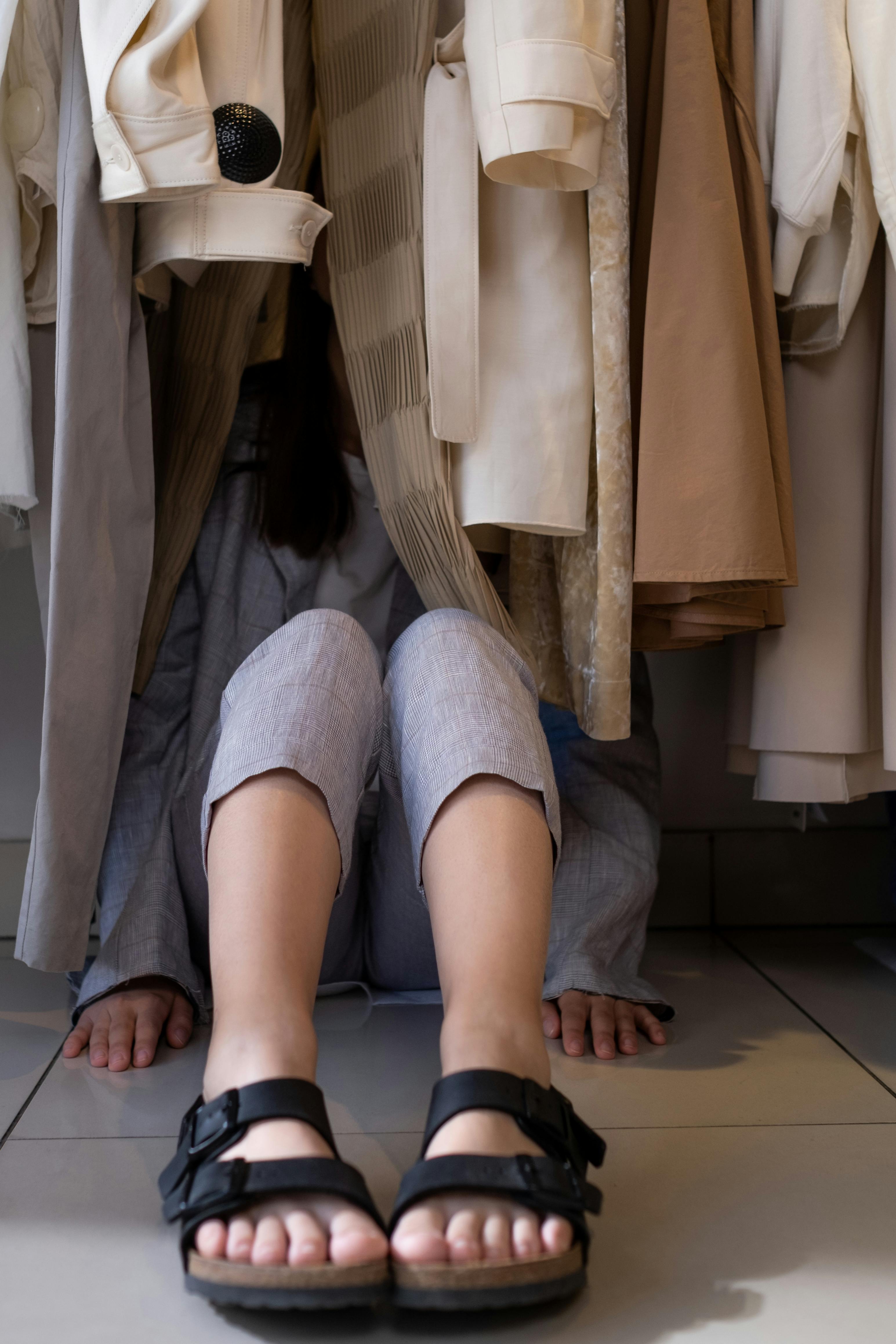 Eine Frau, die sich in einem Kleiderschrank versteckt | Quelle: Pexels