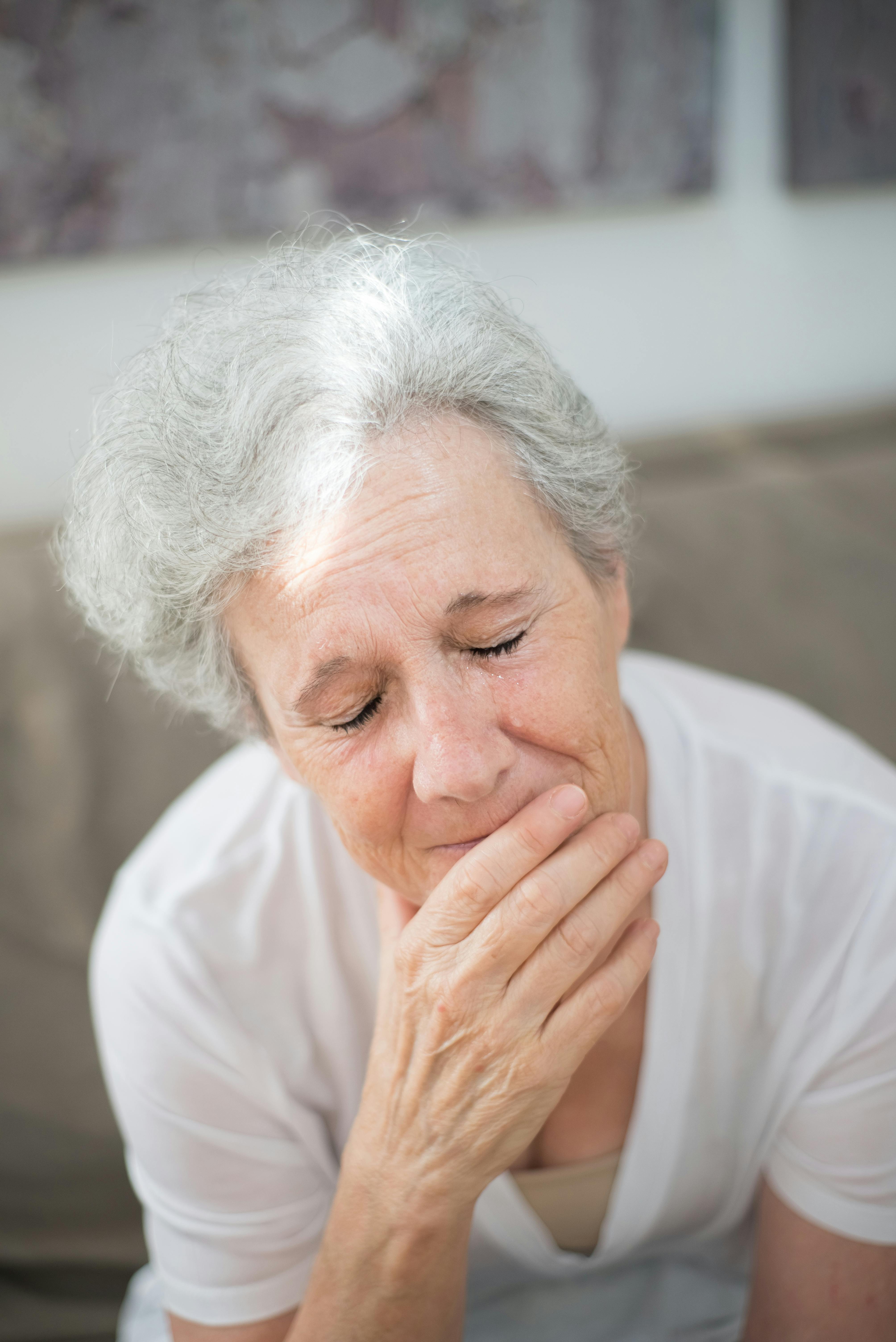 Eine aufgebrachte ältere Frau, die mit geschlossenen Augen weint | Quelle: Pexels