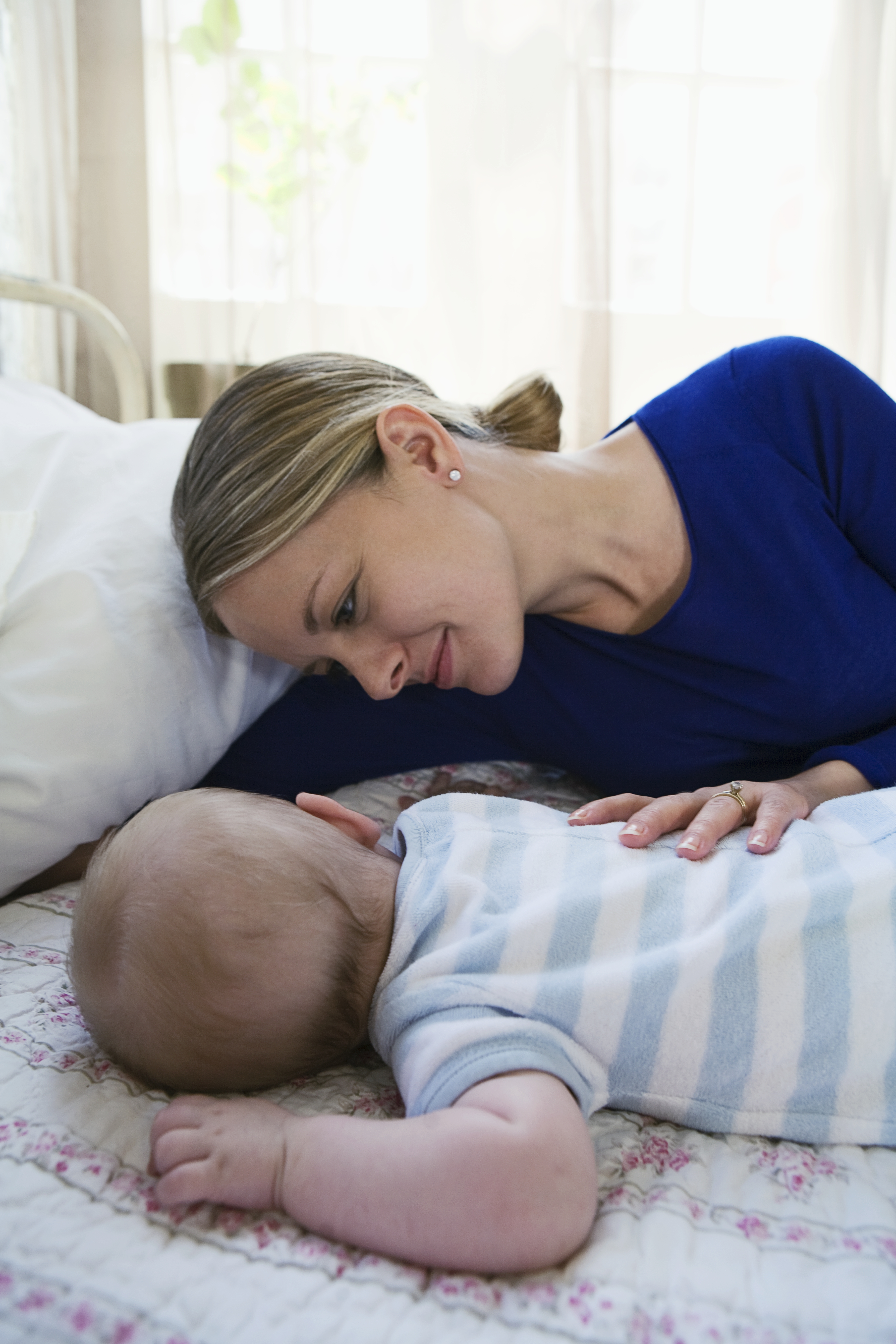 Eine Frau beobachtet ihr Baby beim Schlafen | Quelle: Getty Images