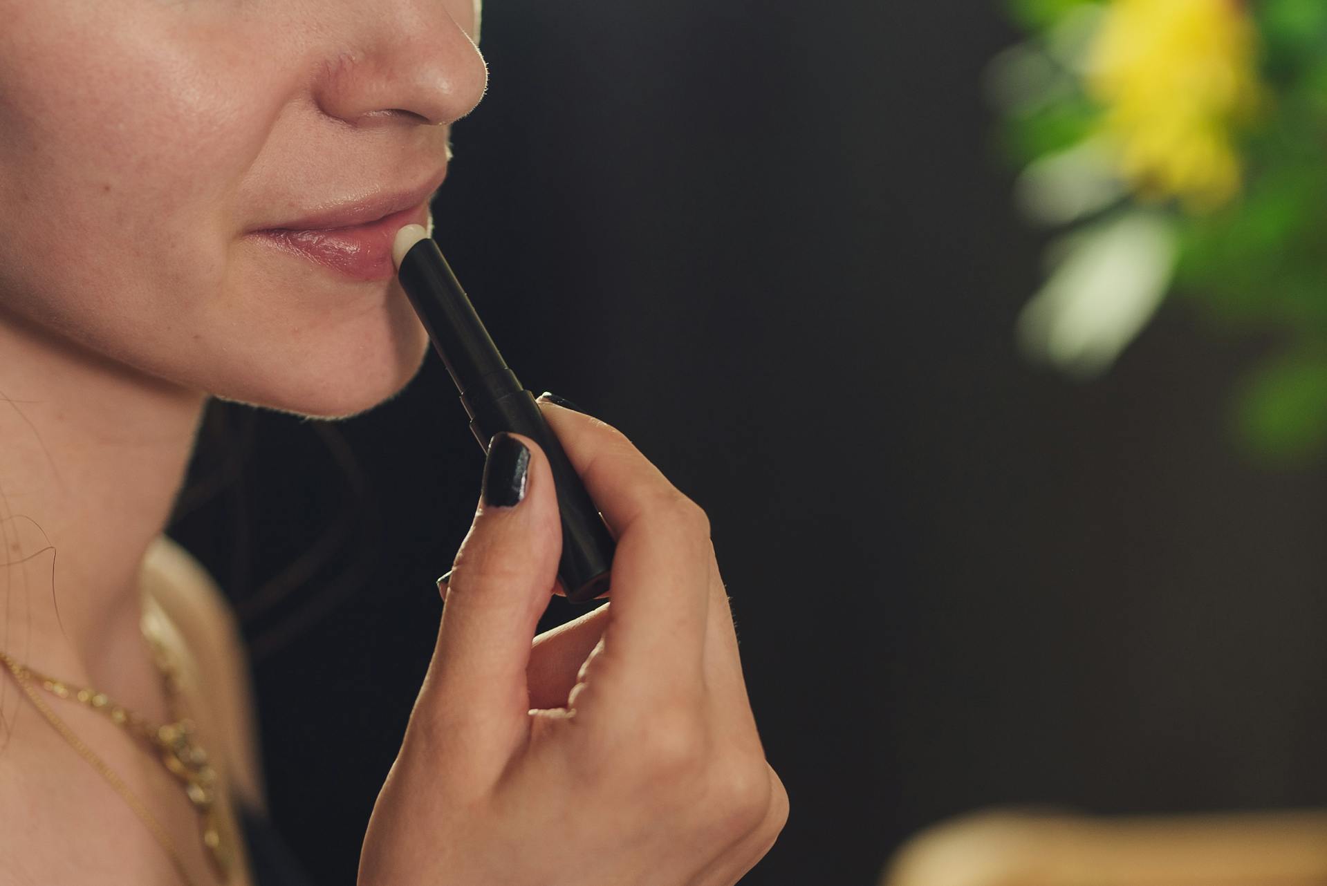 Eine Nahaufnahme einer Frau, die Lippenstift aufträgt | Quelle: Pexels