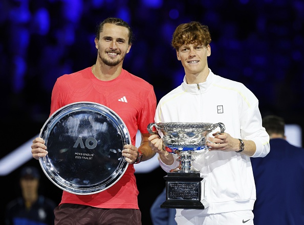 Jannik Sinner (r.) posiert mit der Trophäe nach seinem Sieg bei den Australian Open neben Finalist Alexander Zverev, Melbourne, 26. Januar 2025. | Quelle: Getty Images