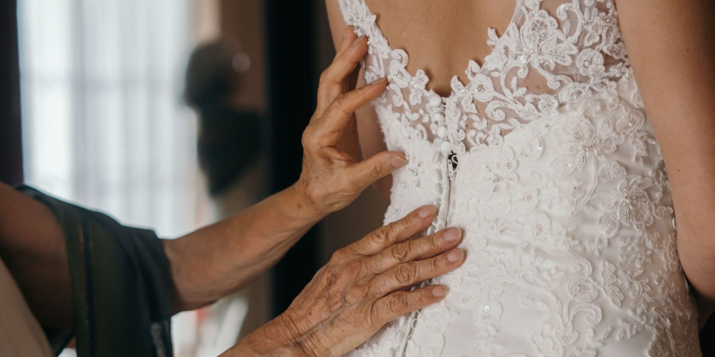 Der Braut wird geholfen, ihr Spitzenhochzeitskleid anzuziehen | Quelle: Pexels