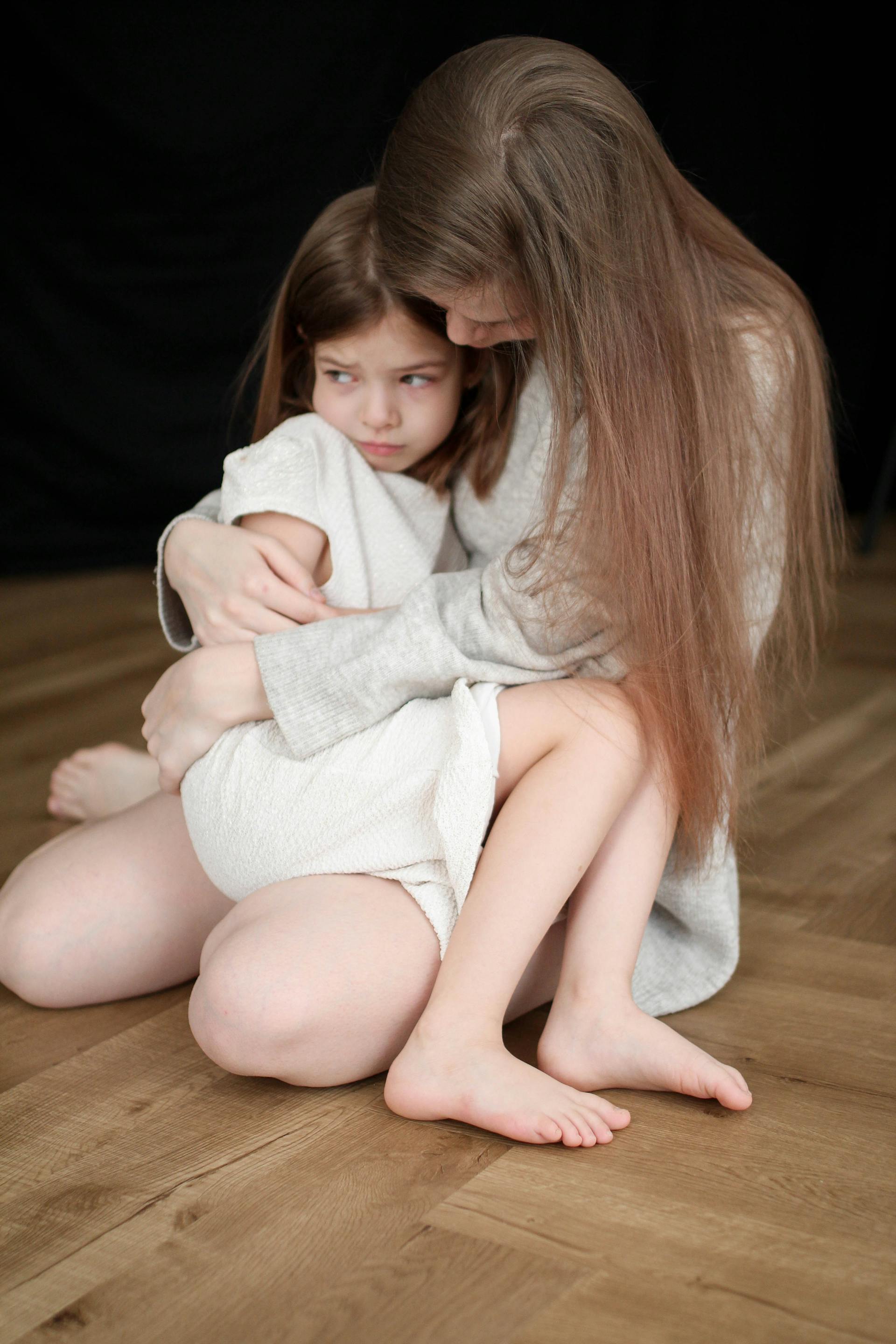 Eine Frau hält ein verängstigtes kleines Mädchen | Quelle: Pexels