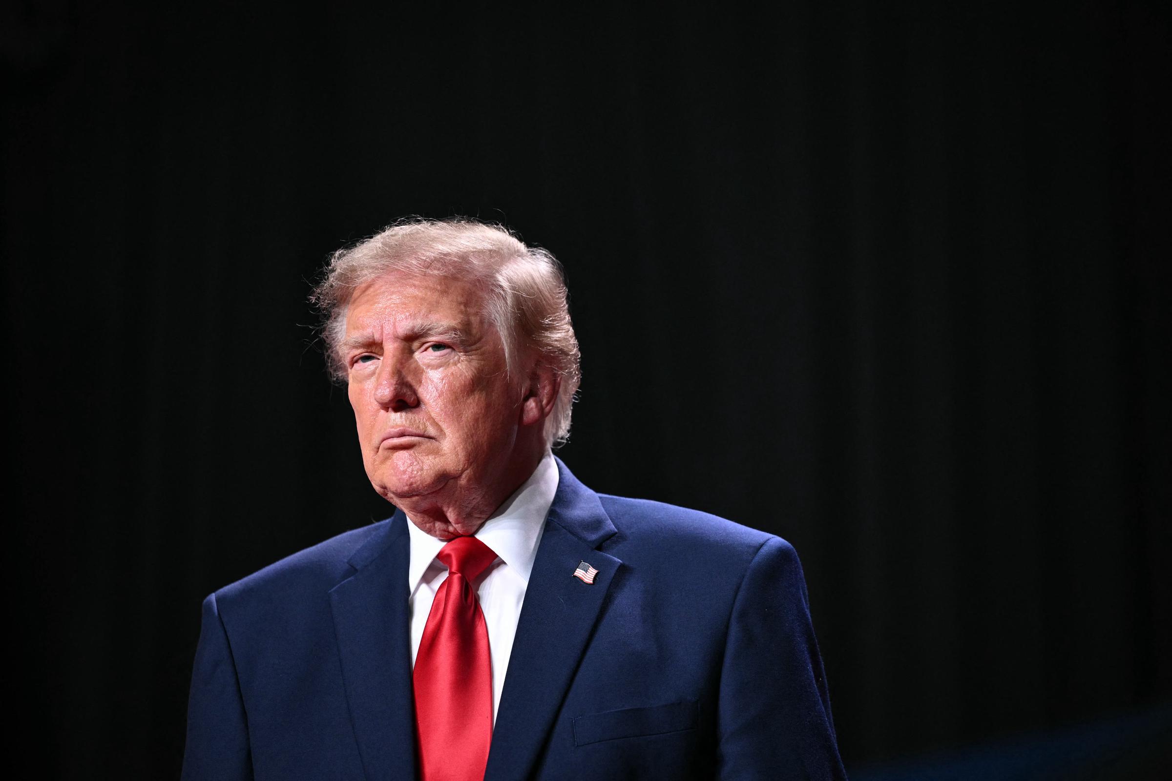 Donald Trump posiert in einem marineblauen Anzug und einer lila Krawatte, als er die Ernennung seiner neuen Pressesprecherin bekannt gibt. Dabei lobt er ihre Arbeit im Wahlkampf und bekundet sein Vertrauen in ihre Fähigkeit, die Agenda seiner Regierung zu vermitteln. | Quelle: Getty Images