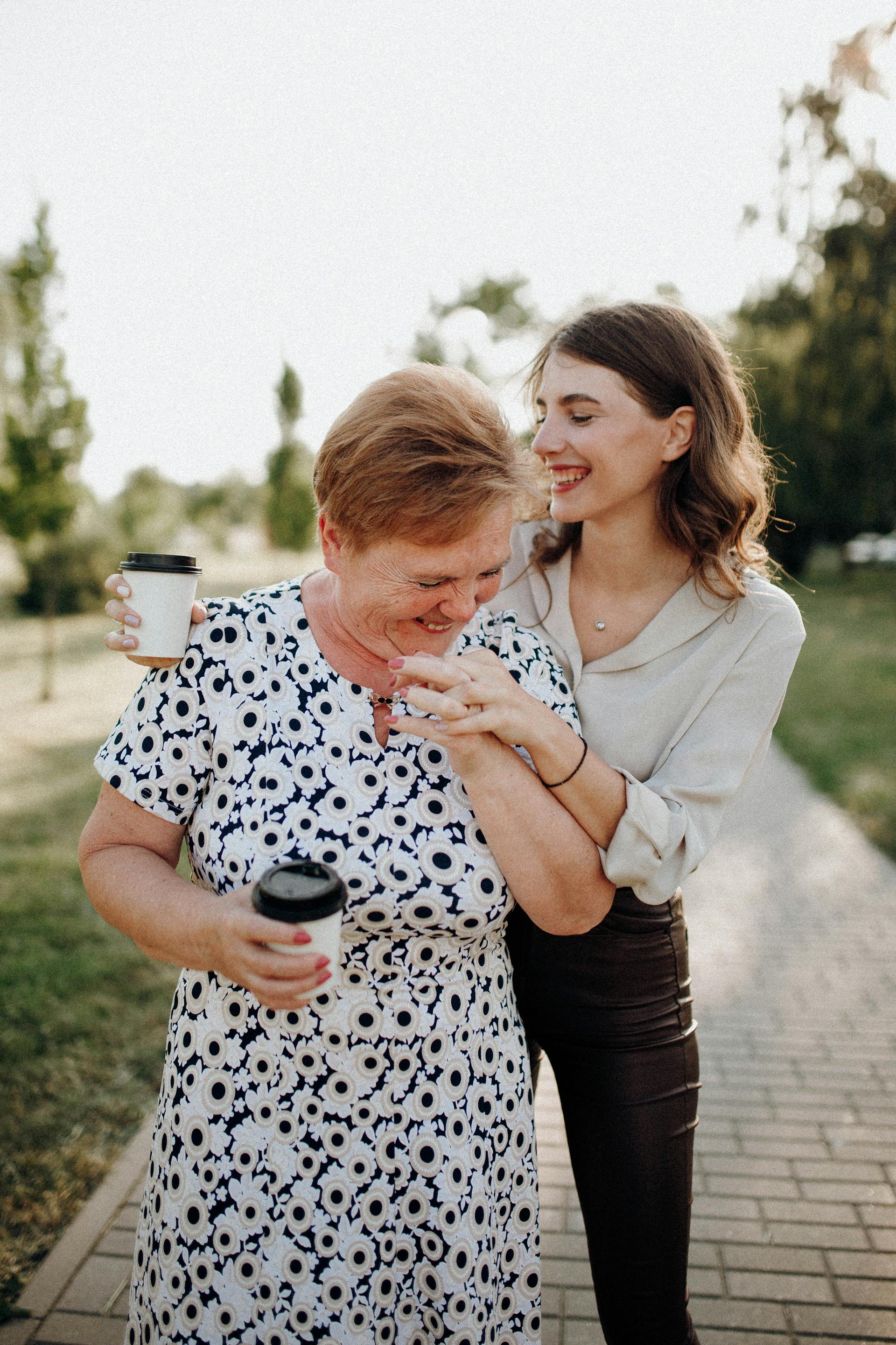 Ein glückliches Mutter-Tochter-Duo mit Kaffeetassen in der Hand | Quelle: Pexels