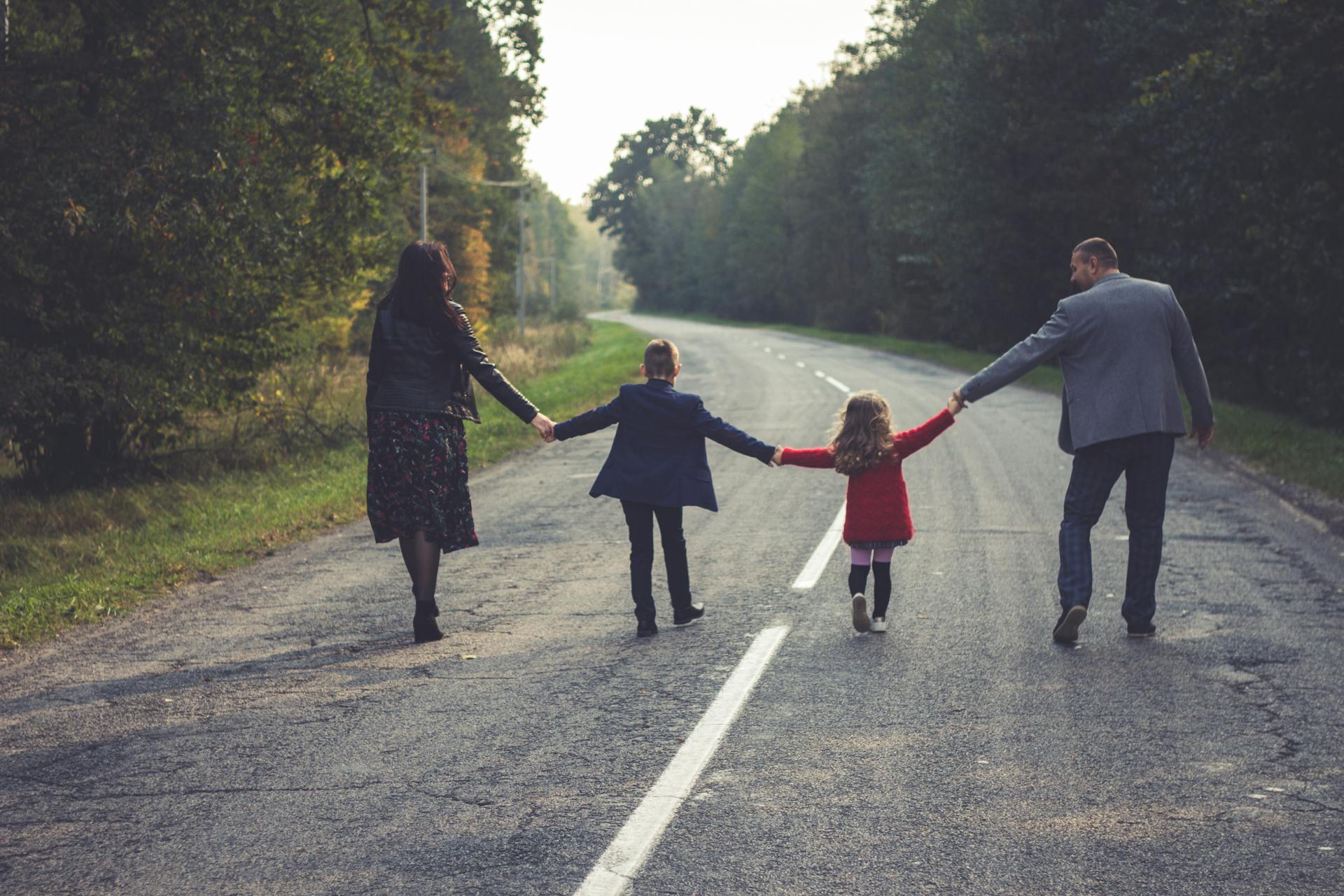 Eine vierköpfige Familie geht eine Straße entlang | Quelle: Pexels