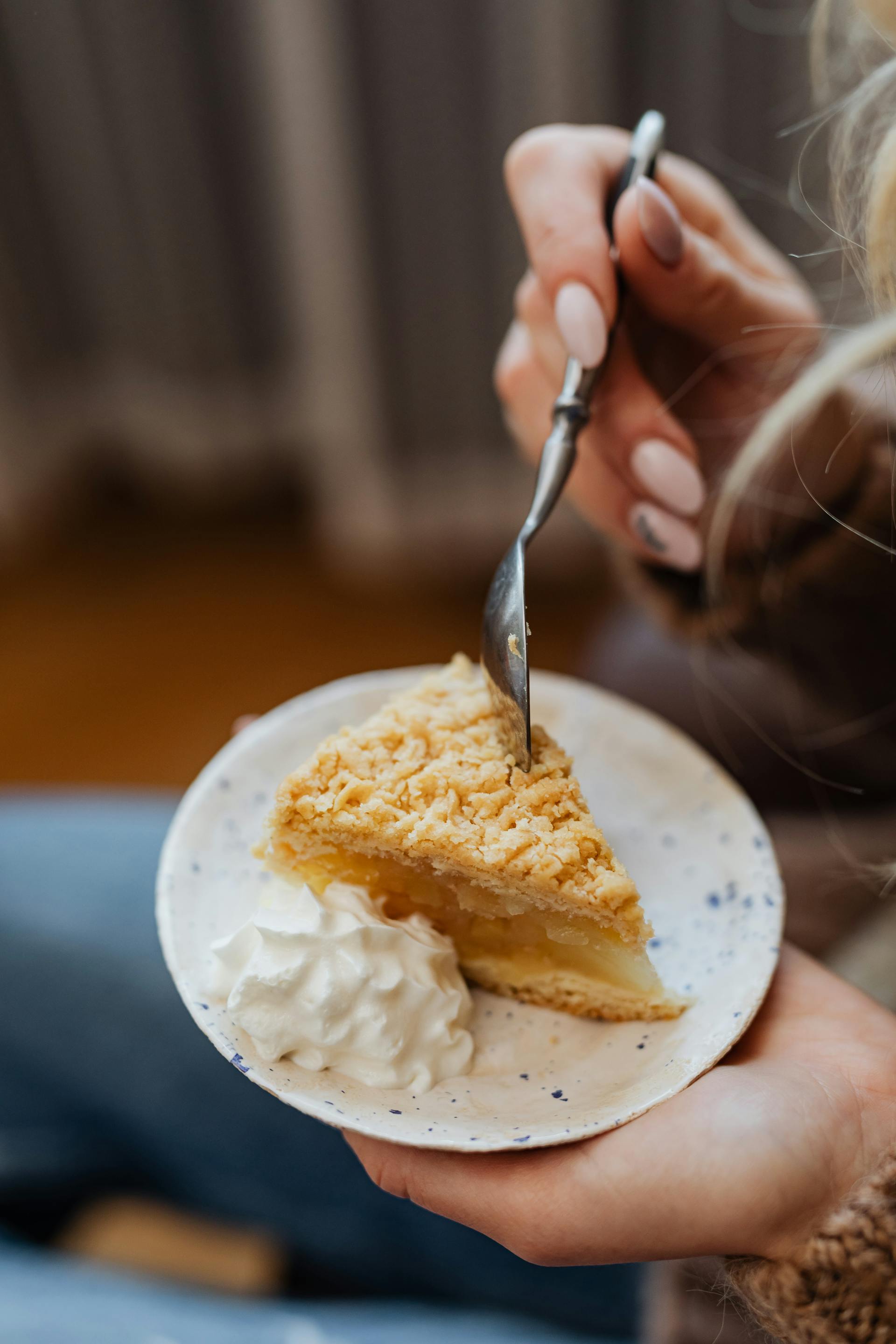 Eine Person hält ein Stück Kuchen in der Hand | Quelle: Pexels